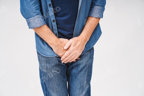 Preview: Close up of mature man suffering from pain isolated on white. Urology problems