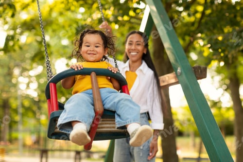 Preview: Smiling Korean Mother Swinging Baby On Swing On Playground