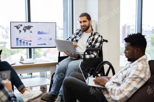 Preview: Man in wheelchair leading meeting in modern office with diverse colleagues