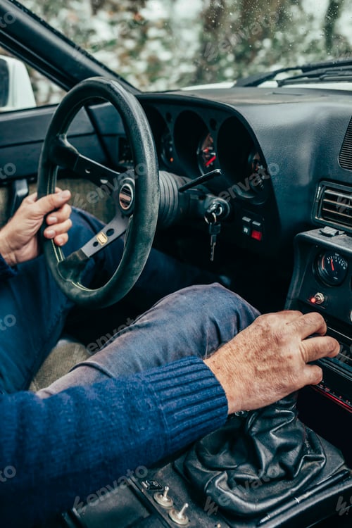 Preview: Man driving in classic car in snowy winter forest