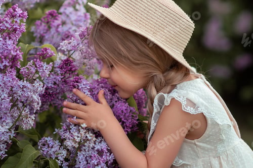 Preview: beautiful caucasian girl in pink lilac flowers in spring at sunset