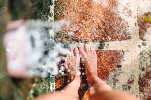 Preview: Closeup of female legs under a beach shower
