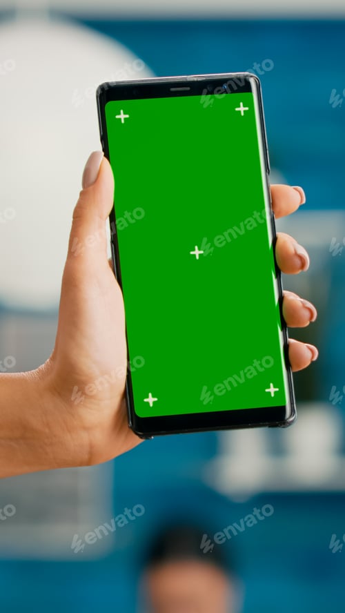 Preview: Hands of freelencer holding vertical mock up green screen chroma key smartphone