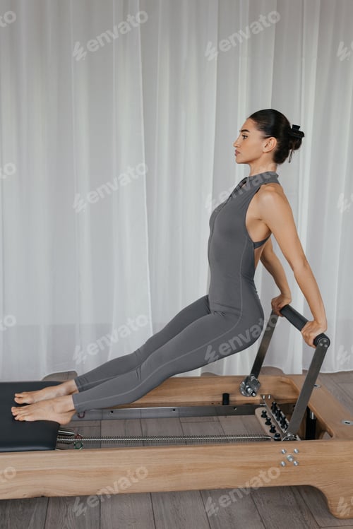 Preview: Standing Roll Down pilates exercise on reformer with athletic woman
