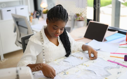 Preview: Happy female dressmaker working in workshop studio