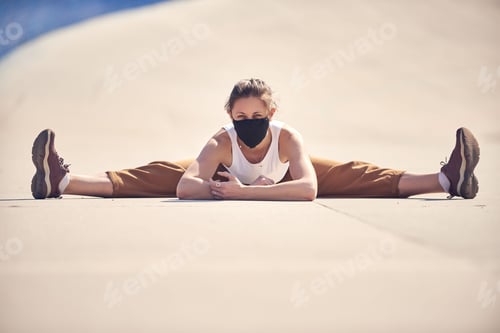 Preview: Woman is doing yoga at empty city in a mask. Epidemic of Coronavirus concept photo