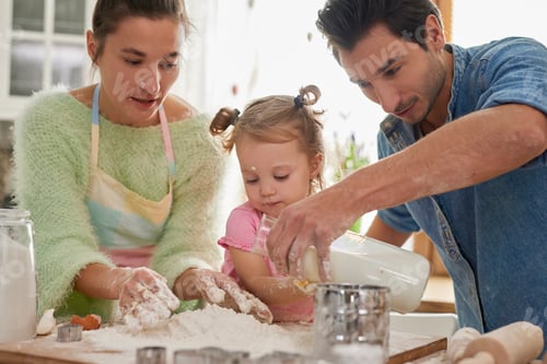 Preview: Little girl making cookies with parents