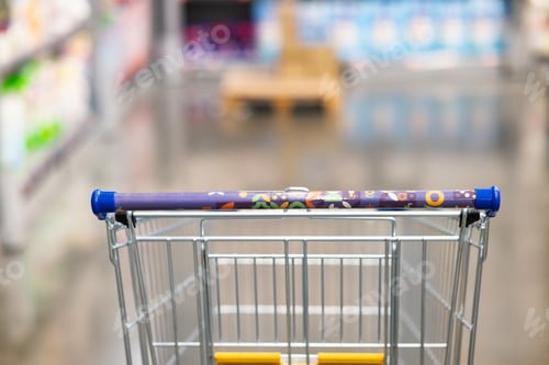 Preview: Abstract blurry photo of a supermarket with an empty shopping cart concept.