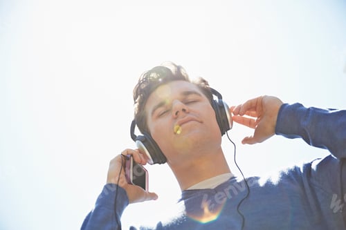 Preview: Young man wearing headphones listening to music