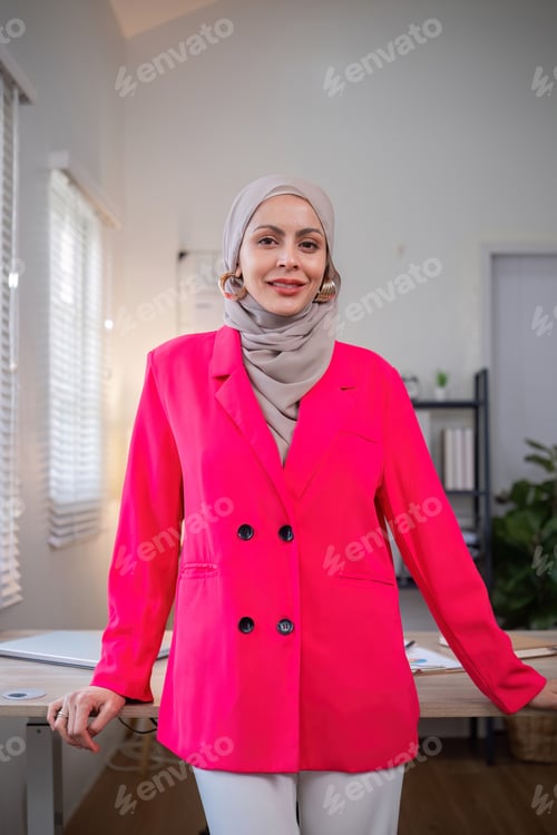 Preview: Confident Muslim businesswoman standing in front of desk in office
