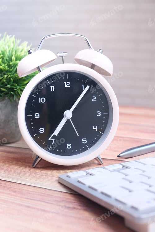 Preview: stack of books , laptop and clock on table close up