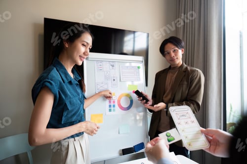 Preview: ux developer and ui designer presenting mobile app interface design on whiteboard in meeting at