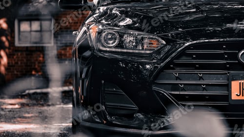 Preview: Closeup of a shiny modern black car parked outdoors during daylight