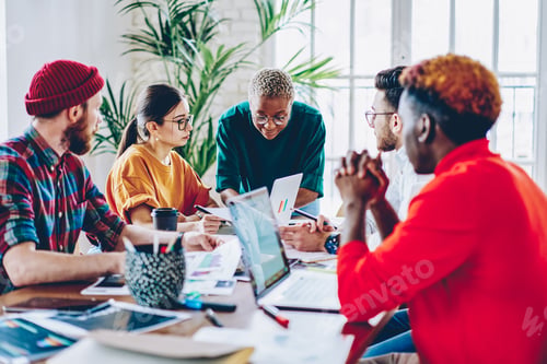 Preview: Crew of skilled coworkers brainstorming during cooperative working process at desk
