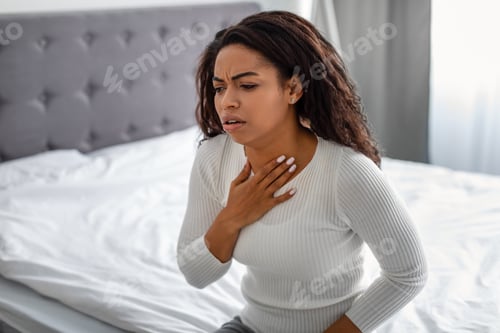 Preview: Young black woman coughing, suffering from sore throat