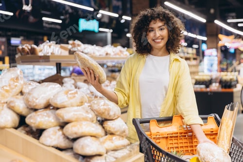 Preview: Young Woman Choosing Bread in Supermarket Bakery