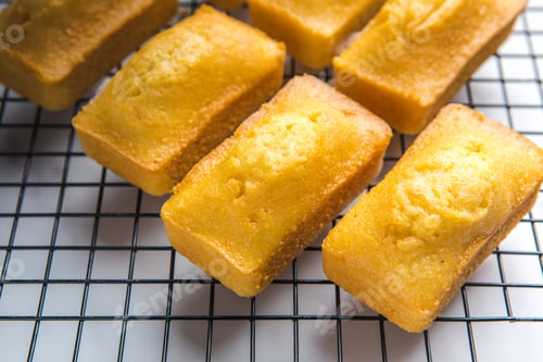 Preview: Close-up of corn muffins on plate with bowl of corn meal and additional muffins in the background.