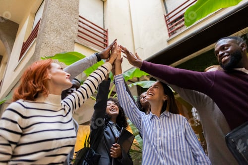 Preview: Happy multiracial business team giving high five celebrating success in coworking space