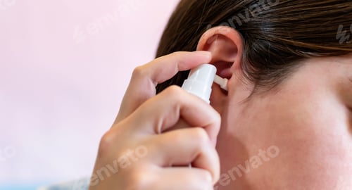 Preview: Girl using a spray to clean the ears, clogged by the secretion of the ear.