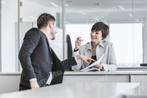 Preview: Businesspeople standing doing paperwork in office