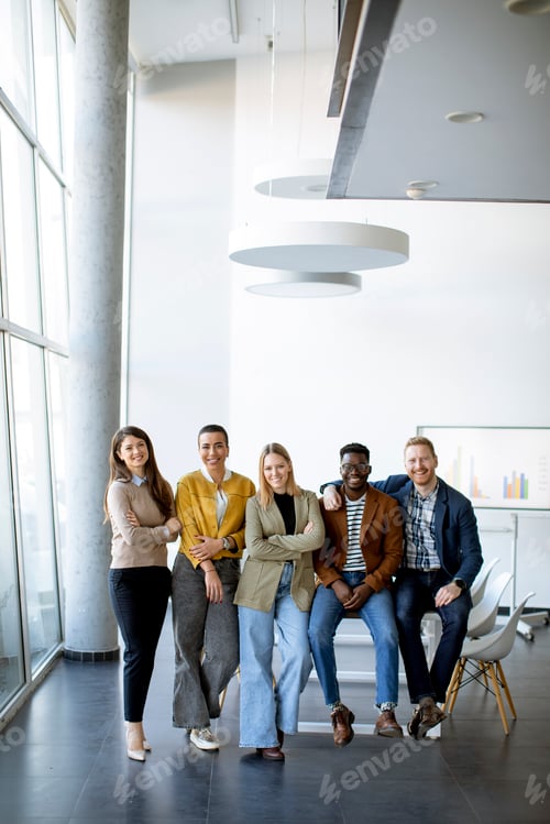 Preview: Group of positive businesspeople standing together in the office