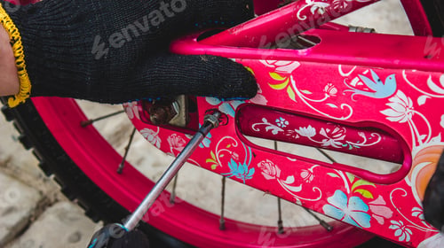 Preview: A father repairs his daughter's bike.