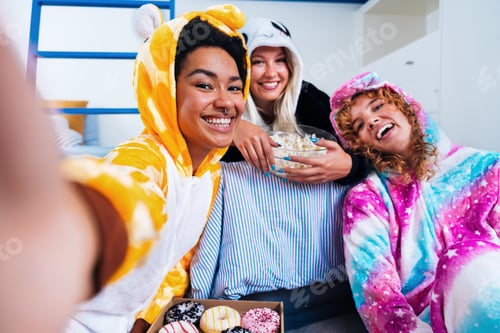 Preview: Multiethnic group of young female friends having pajamas party at home