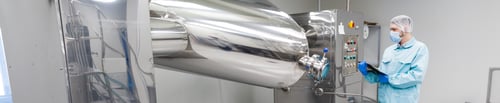 Preview: scientist stand check readings about machine with rolling barrels