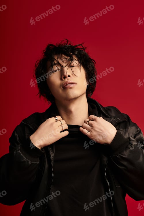 Preview: Urban melancholy asian model poses stylishly in a studio with red backdrop