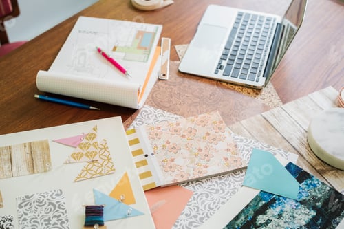 Preview: Craft materials, fabric and paper, patterns and a notebook and tablet.