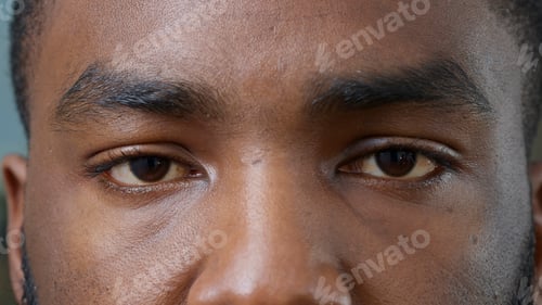 Preview: Macro shot of young man showing brown eyes on camera