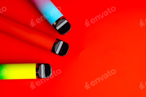 Preview: Colorful disposable electronic cigarettes on red background