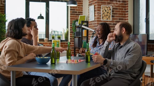 Preview: Happy friends enjoying charades board game at home gathering