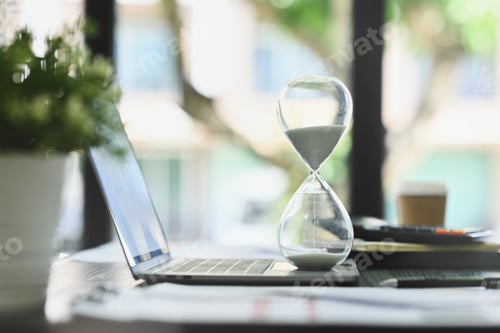 Preview: Close up view of hourglass on office desk measuring time. Time management concept