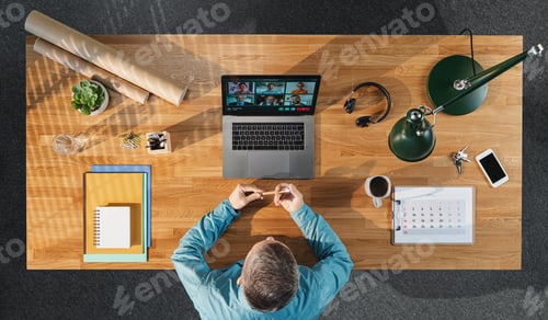 Preview: Top view of businessman working on computer at desk in home office, video call concept.