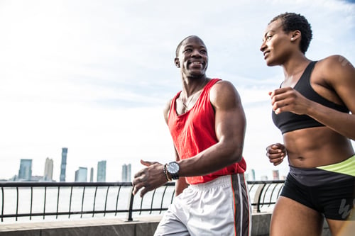 Athletic Man and Woman Jogging Near the City