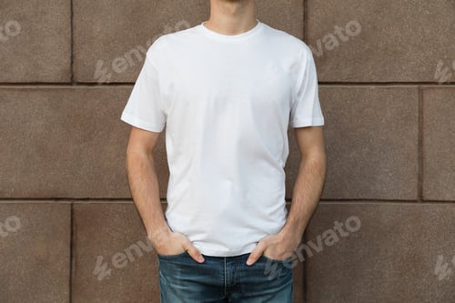 Preview: Men in blank white t-shirt against building, space for text