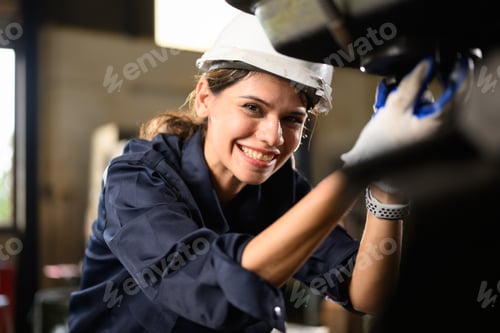 Preview: Confident female technician engineer worker checking and inspecting machine