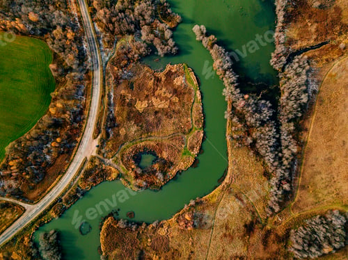 Preview: Aerial view of winding river and road in golden colored fall forest