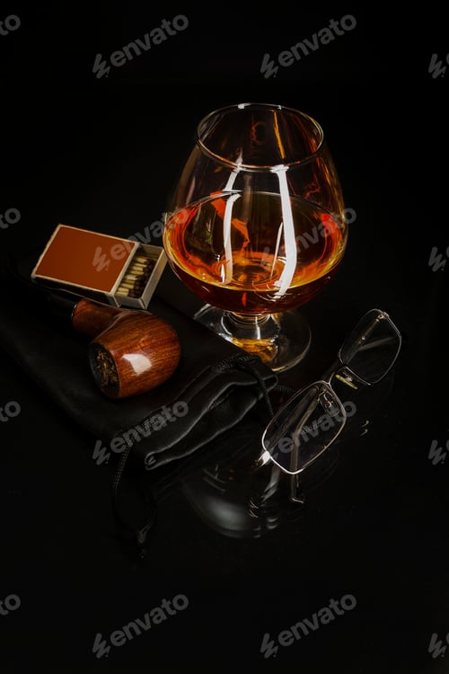 Preview: Glass of cognac and smoking pipe