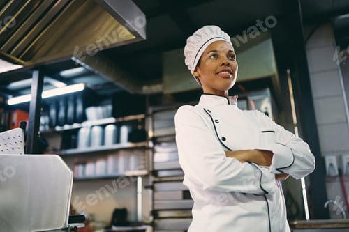 Preview: Below view of confident black female chef in the kitchen.