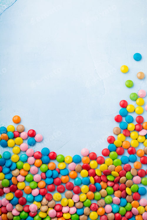 Preview: Chocolate round candy in a multicolored sugar glaze on light blue background. Selective focus. Top v