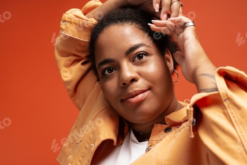 Preview: Stylish plus size woman showcases trendy autumn outfit in vibrant studio setting