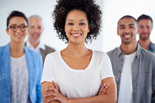 Preview: Beautiful young businesswoman smiling with coworkers in the background