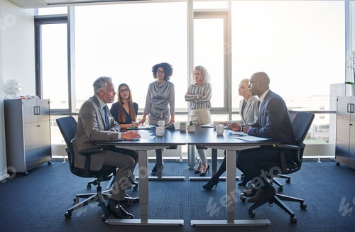 Preview: Businesspeople talking around a table in a modern office