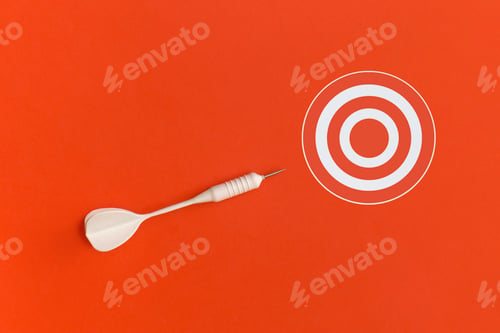 Preview: Dart and red target on a yellow background. Top view. Flat lay.