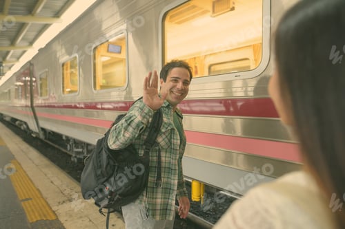 Preview: Persian tourist man and young Asian tourist woman together at the railway station