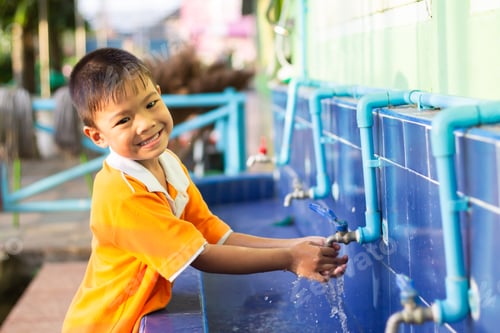 Preview: Asian student child boy washing his hands before eating food and after play the toys at the washing