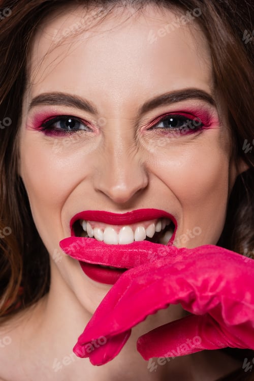 Preview: portrait of young woman with makeup biting magenta color glove