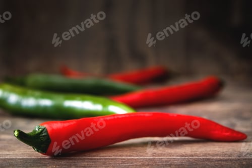 Preview: Red and green chili peppers resting on wooden table
